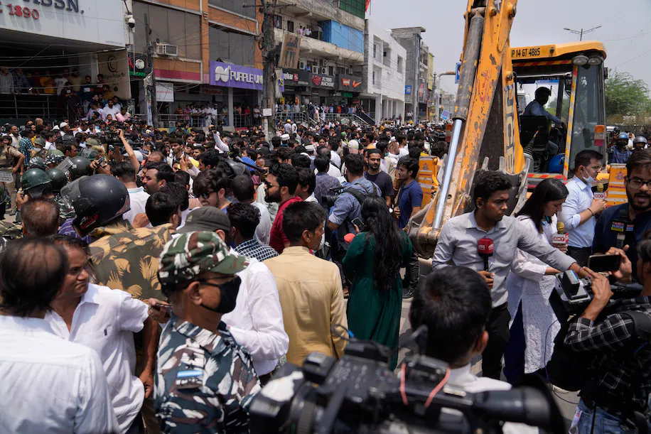 Residents of Shaheen Bagh surround officials during a demolition drive in New Delhi on May 9. (Manish Swarup/AP)